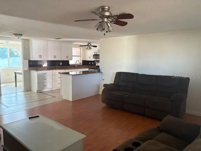 a living room with stainless steel appliances kitchen island granite countertop furniture and a fireplace