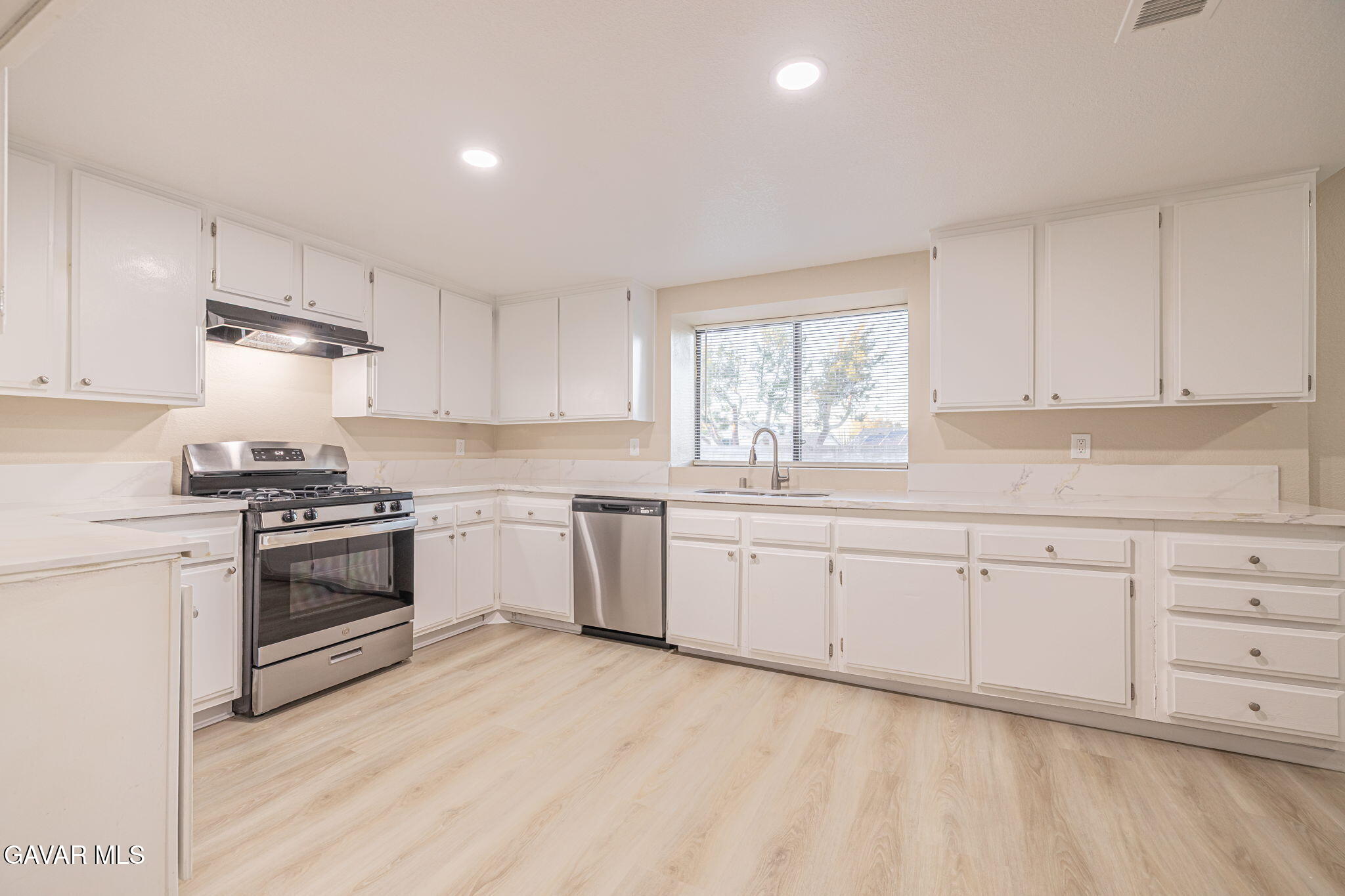 1201 Camran Avenue Lancaster, CA 93535 - Photo 35 of 49 a kitchen with granite countertop white cabinets and white appliances