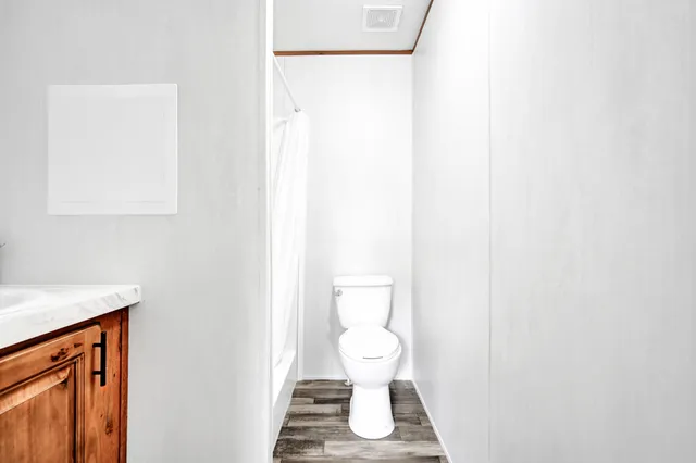 a white toilet sitting next to a shower