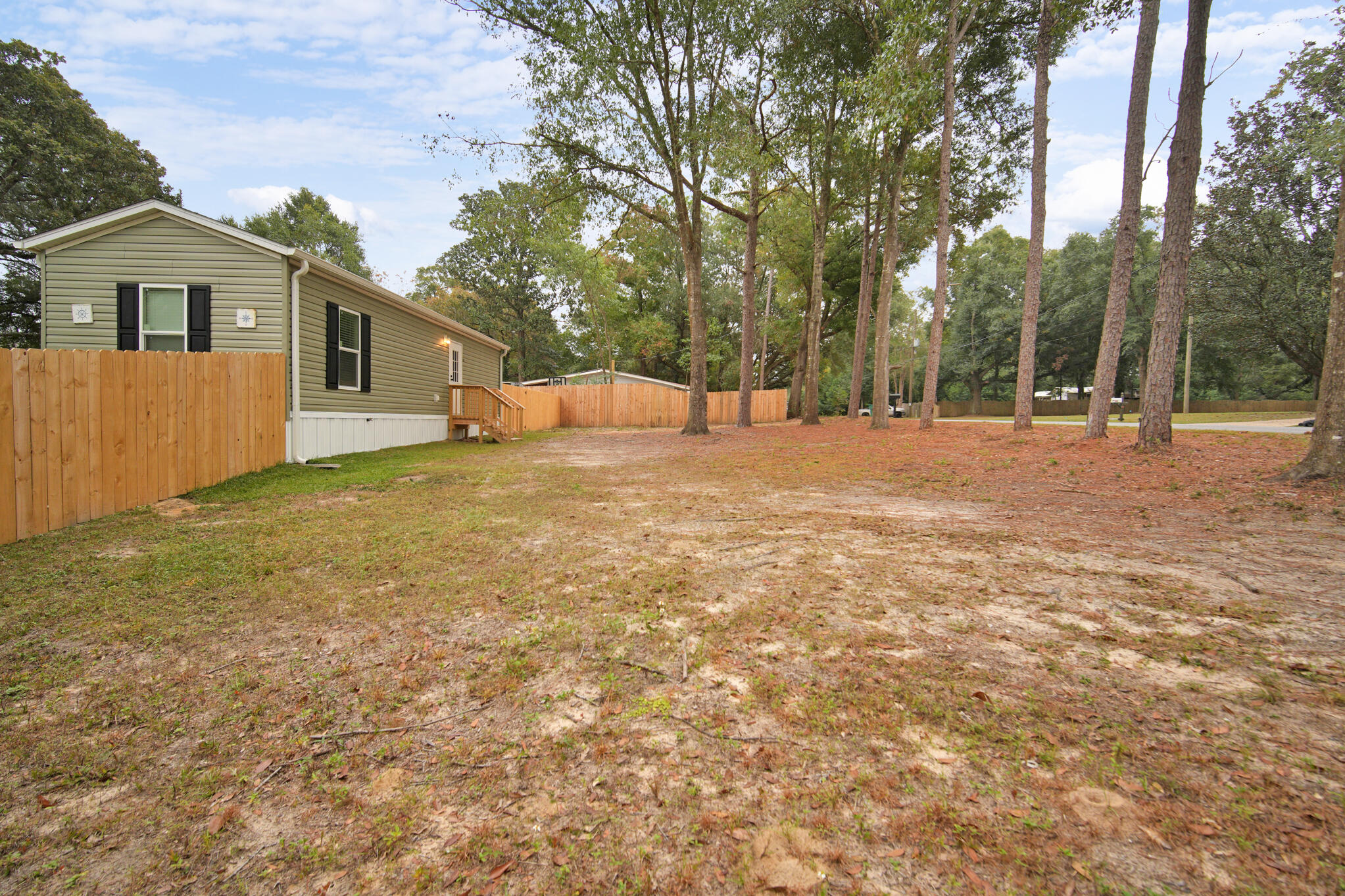2303 Lewis Street Crestview, FL 32536 - Photo 6 of 32 a view of a yard in front of a house with large trees