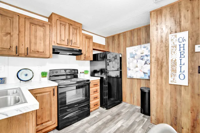 a kitchen with stainless steel appliances granite countertop a refrigerator a stove and a sink with cabinets