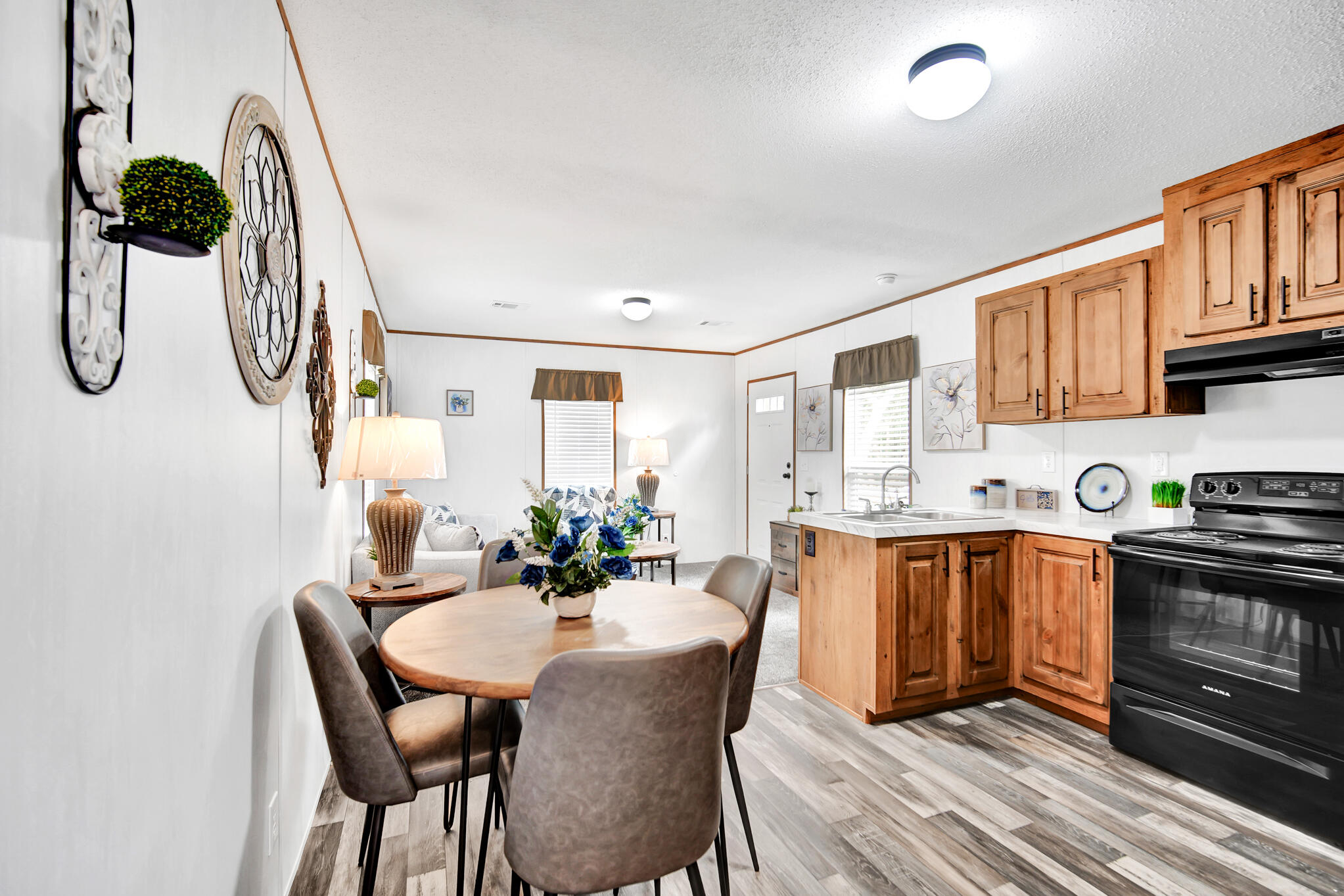 2303 Lewis Street Crestview, FL 32536 - Photo 10 of 32 a kitchen with stainless steel appliances kitchen island granite countertop a table chairs in it and wooden floors