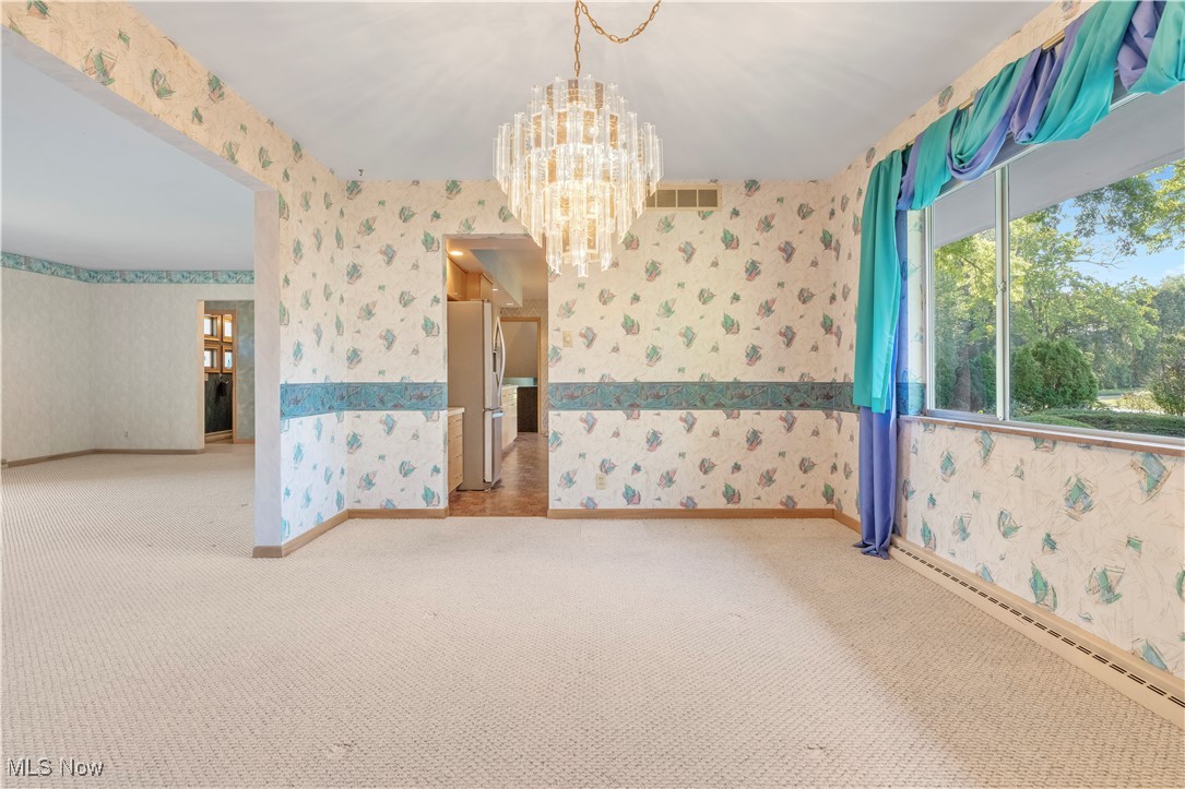 2490 Brice Road Akron, OH 44313 - Photo 12 of 42 Dining room featuring carpet floors, a notable chandelier, and a baseboard radiator
