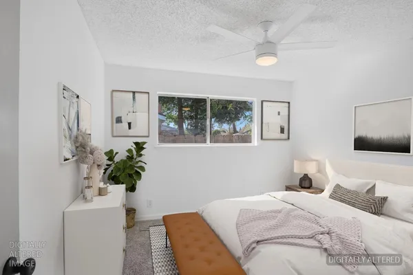 a bedroom with a bed and a potted plant