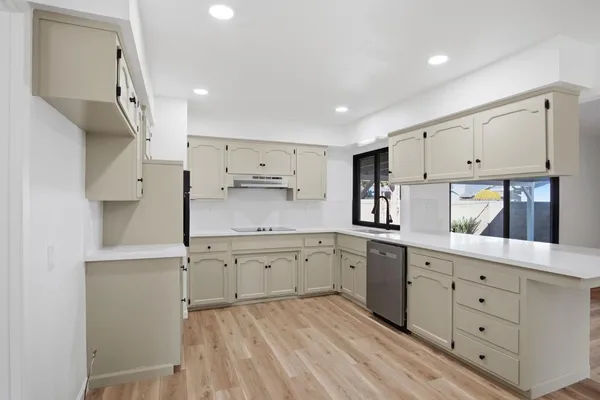 a kitchen with granite countertop white cabinets white stainless steel appliances and sink