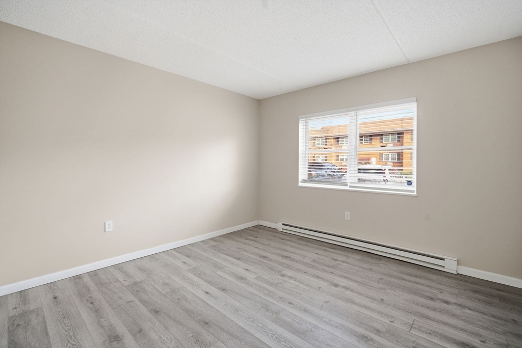 34 Maple Crest Circle, Unit B Holyoke, MA 01040 - Photo 12 of 22 an empty room with wooden floor and windows