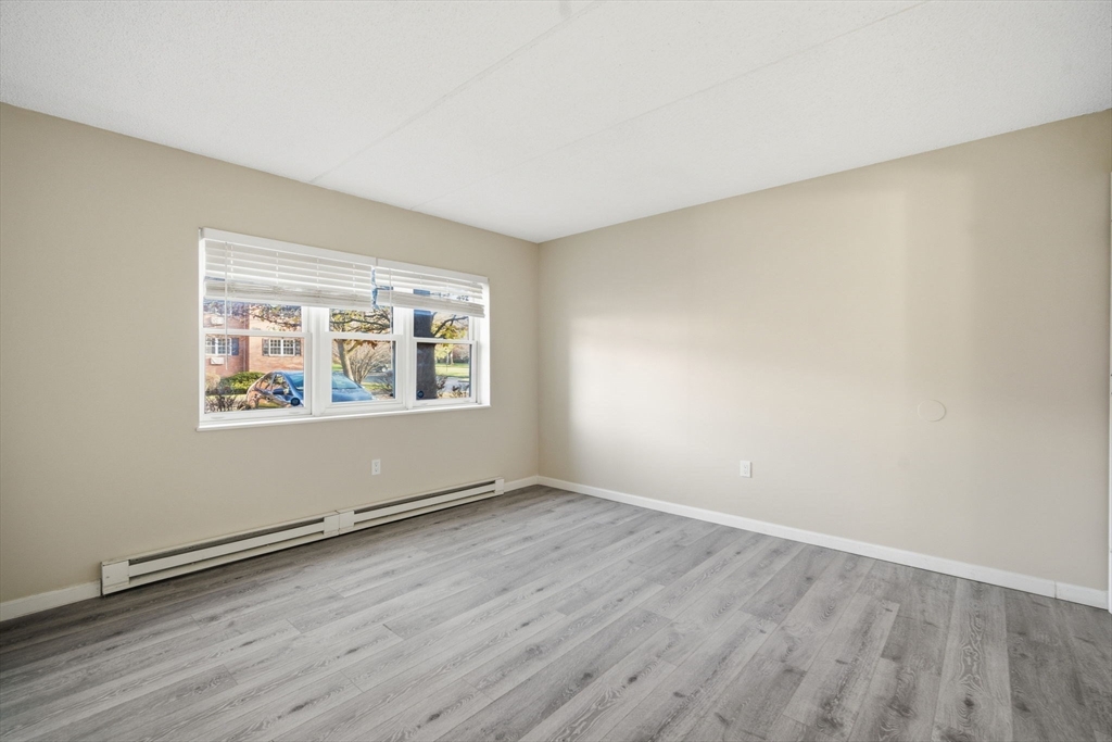 34 Maple Crest Circle, Unit B Holyoke, MA 01040 - Photo 15 of 22 an empty room with wooden floor and windows