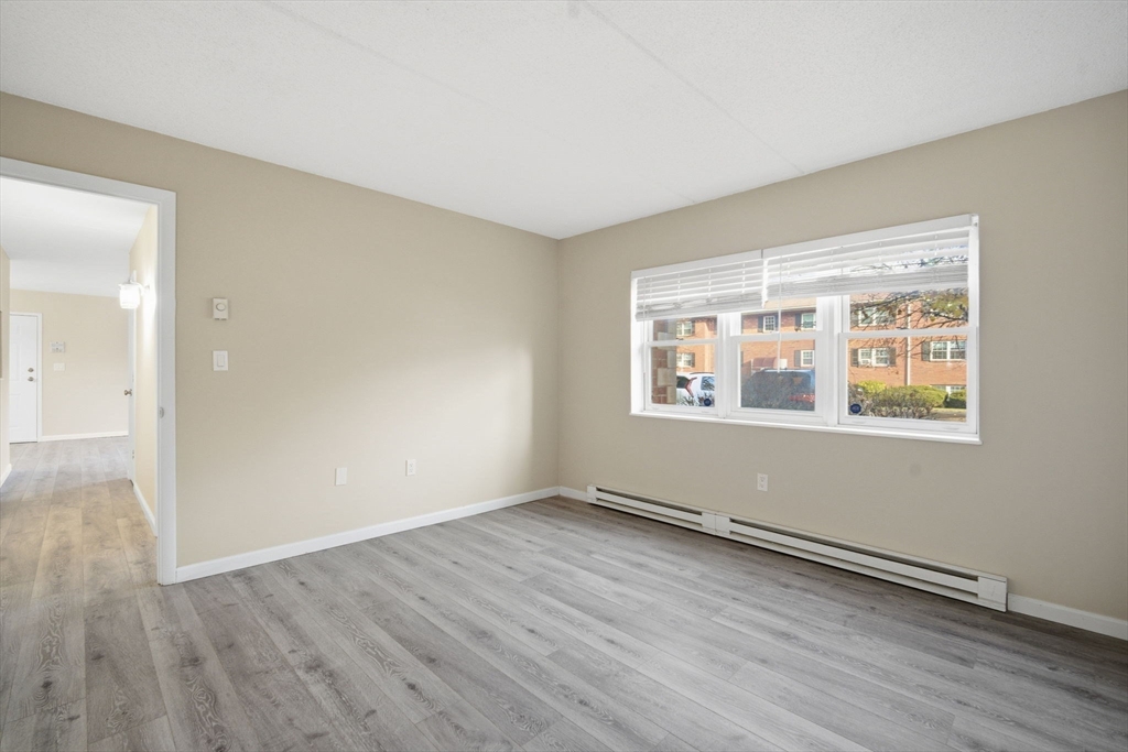 34 Maple Crest Circle, Unit B Holyoke, MA 01040 - Photo 17 of 22 a view of an empty room with wooden floor and a window