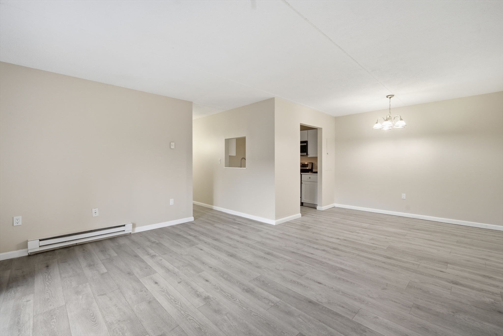 34 Maple Crest Circle, Unit B Holyoke, MA 01040 - Photo 2 of 22 a view of an empty room with wooden floor and a window
