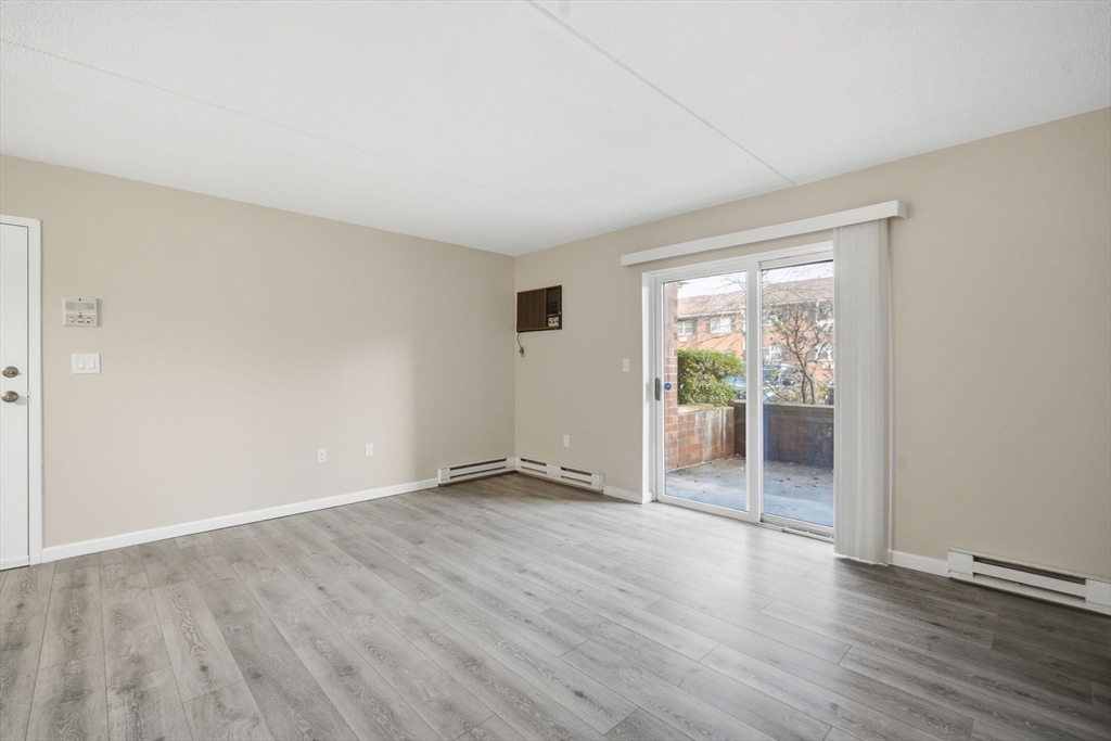34 Maple Crest Circle, Unit B Holyoke, MA 01040 - Photo 5 of 22 an empty room with wooden floor and windows