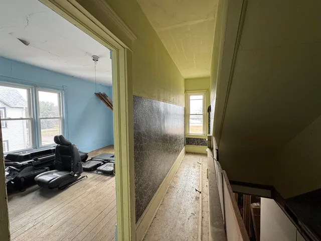 a view of a hallway to a livingroom and a window