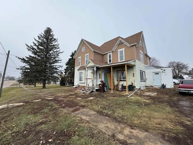 a view of a street with a house and a trees in the background