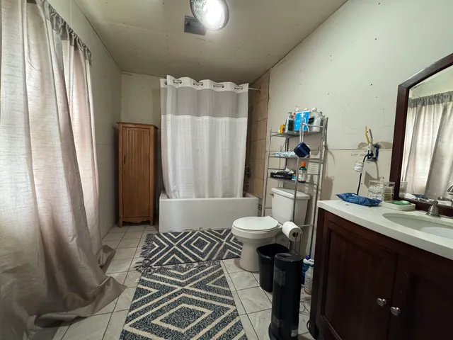 a bathroom with a sink a toilet a mirror and shower