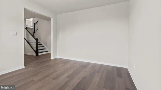 an empty room with wooden floor and stairs