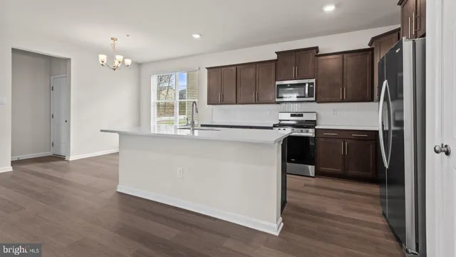 a kitchen with kitchen island a sink stainless steel appliances and cabinets