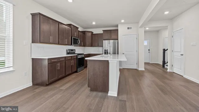 a kitchen with stainless steel appliances granite countertop a stove a sink and a refrigerator