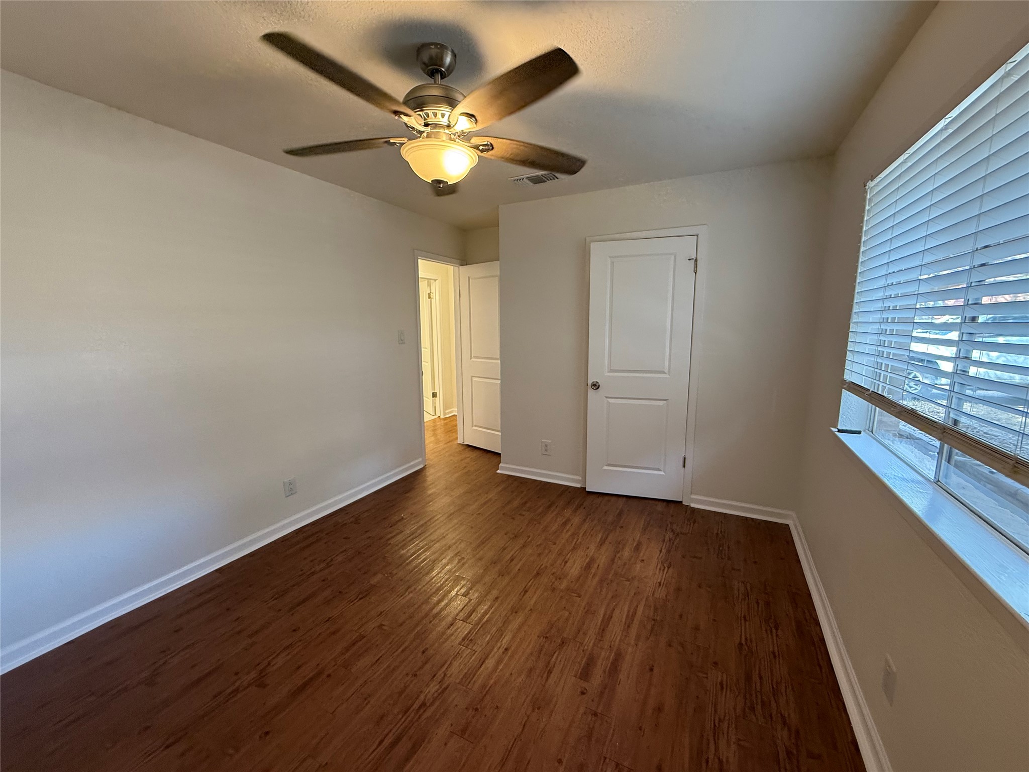 6710 Circle S Road, Unit B Austin, TX 78745 - Photo 10 of 14 a view of an empty room with wooden floor and a window