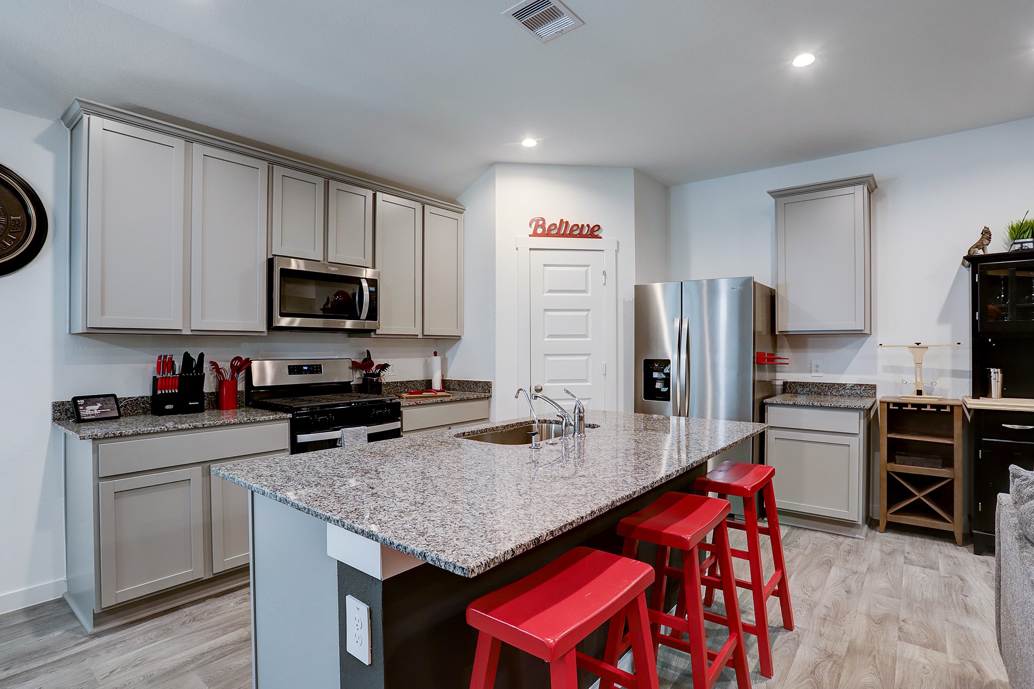 3838 Beltingham Bend Way Fulshear, TX 77441 - Photo 6 of 22 a kitchen with stainless steel appliances granite countertop a stove refrigerator and microwave