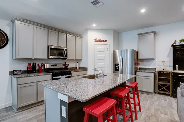 a kitchen with stainless steel appliances granite countertop a stove refrigerator and microwave