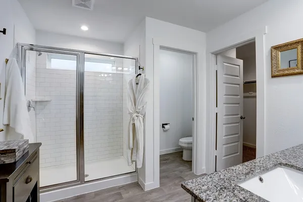 a bathroom with a granite countertop sink toilet and shower