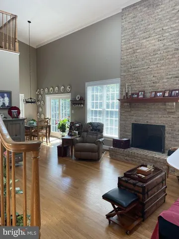 a kitchen with stainless steel appliances granite countertop a stove a sink a dining table and chairs with wooden floor