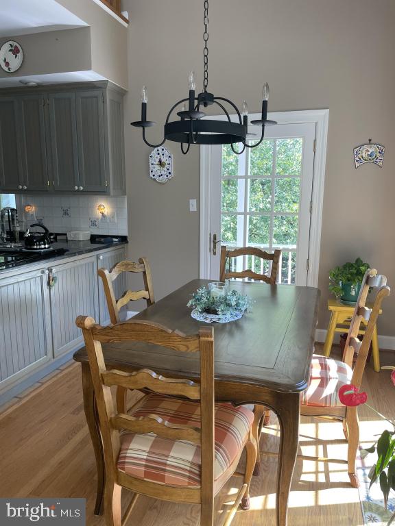 5597 Sedwick Court Frederick, MD 21702 - Photo 24 of 66 a kitchen with stainless steel appliances granite countertop a stove a sink a dining table and chairs with wooden floor