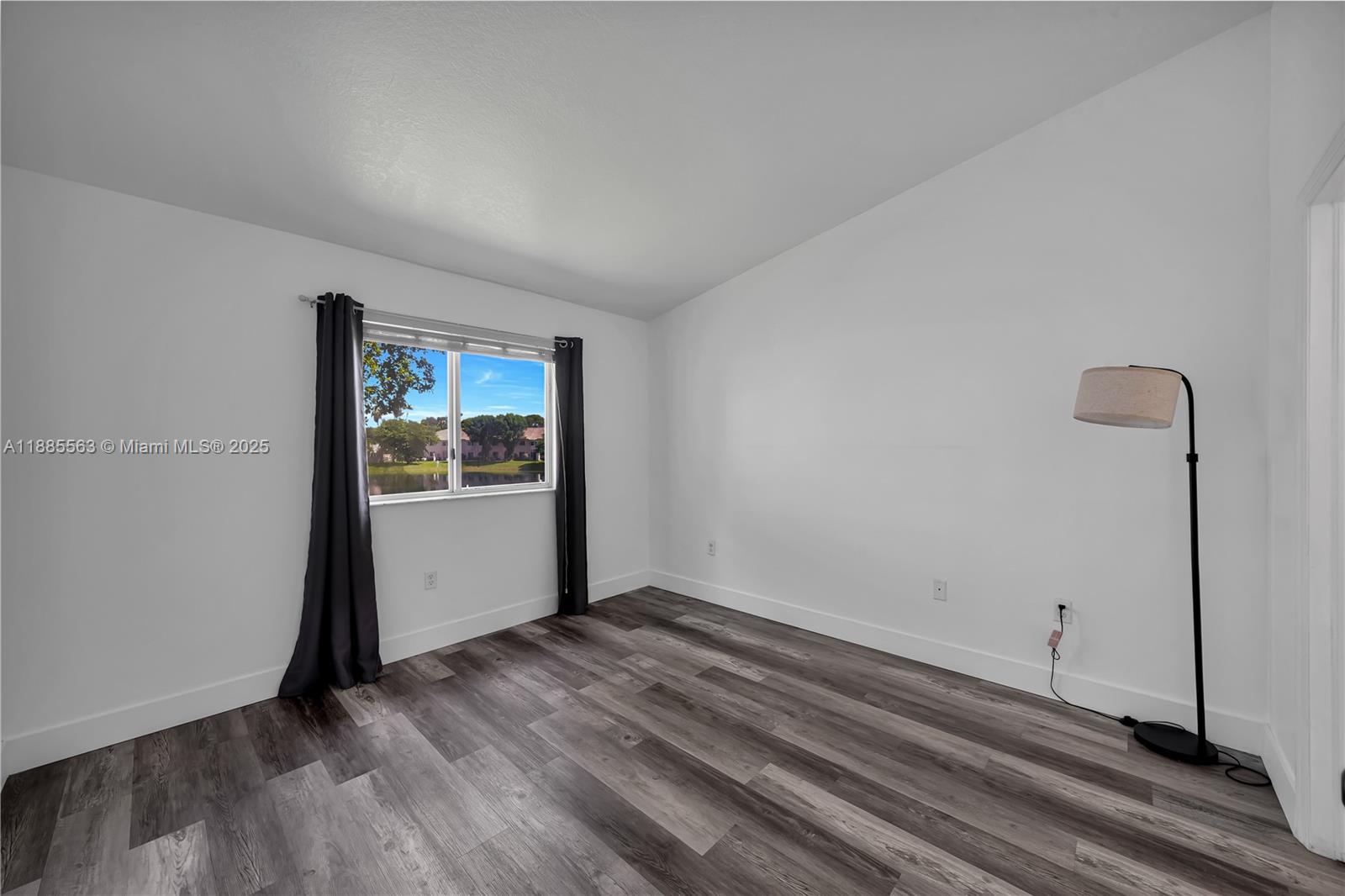 1261 Southeast 27th Street, Unit 203 Homestead, FL 33035 - Photo 13 of 18 a view of an empty room with window and wooden floor