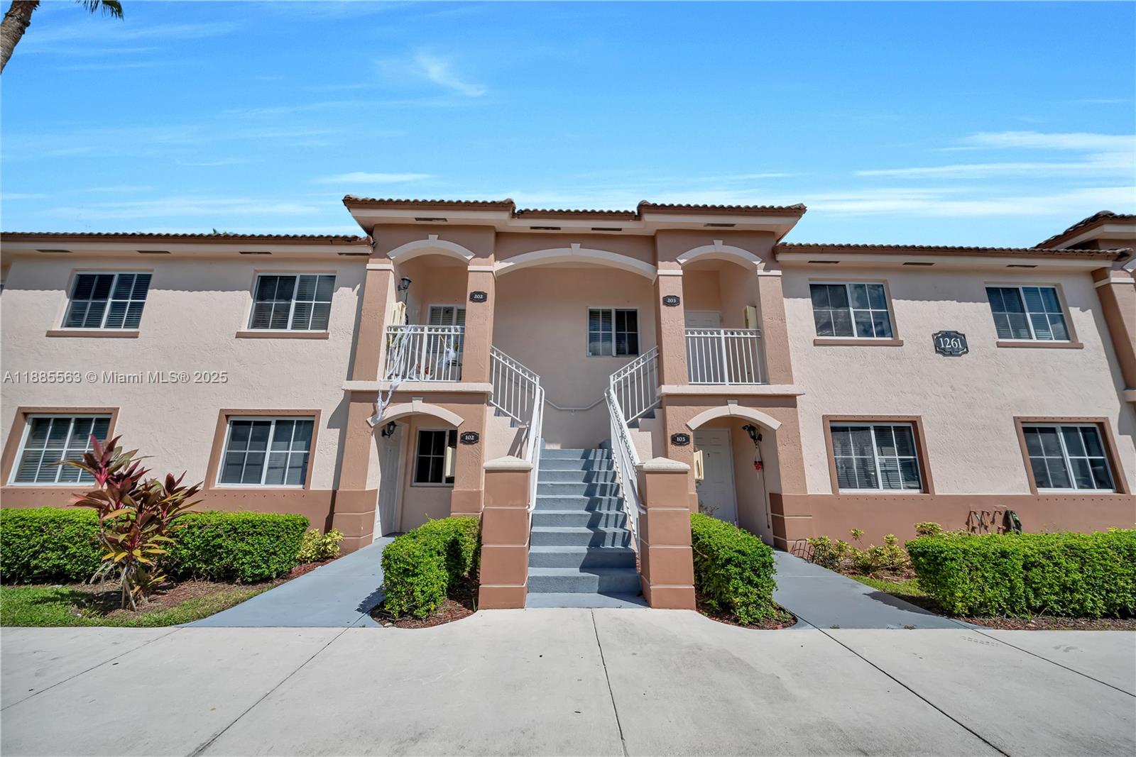 1261 Southeast 27th Street, Unit 203 Homestead, FL 33035 - Photo 2 of 18 a front view of a house with garden