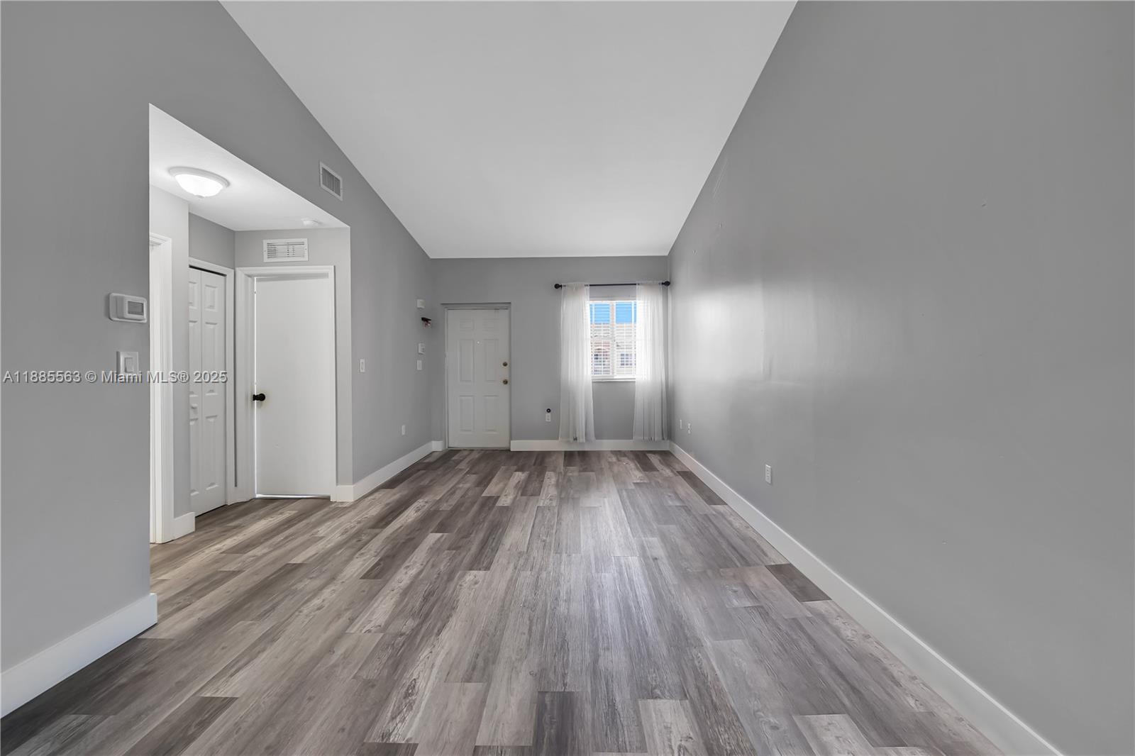 1261 Southeast 27th Street, Unit 203 Homestead, FL 33035 - Photo 5 of 18 wooden floor in an empty room with a window