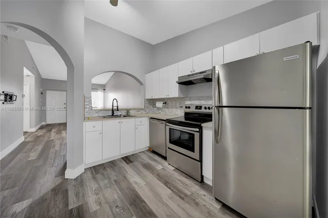 a kitchen with stainless steel appliances a refrigerator sink and cabinets