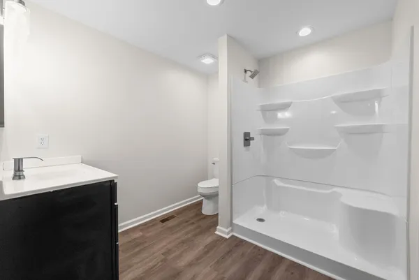 a bathroom with a granite countertop sink toilet and shower