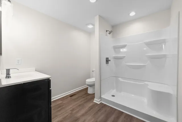 a bathroom with a granite countertop sink toilet and shower