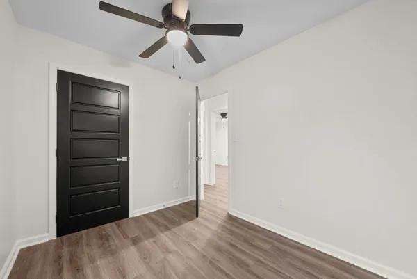 an empty room with closet and a ceiling fan