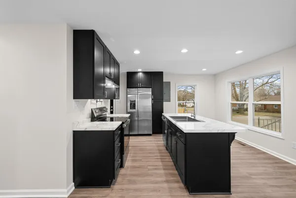 a kitchen with counter top space a sink appliances and cabinets