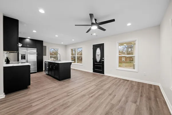 a large kitchen with stainless steel appliances granite countertop a refrigerator and a sink