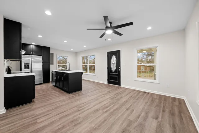 a large kitchen with stainless steel appliances granite countertop a refrigerator and a sink