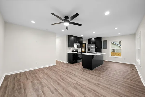 a large kitchen with stainless steel appliances granite countertop a large counter top and wooden floors