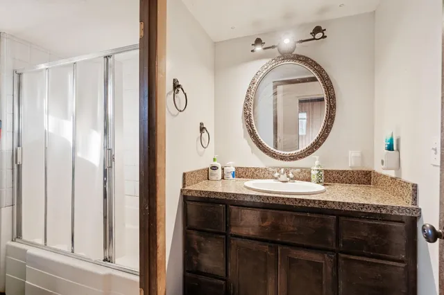 a bathroom with a granite countertop sink and a mirror