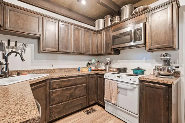 a kitchen with stainless steel appliances granite countertop a sink a stove and cabinets