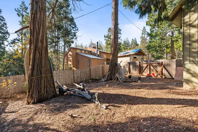 a view of a barn with wooden fence next to a yard