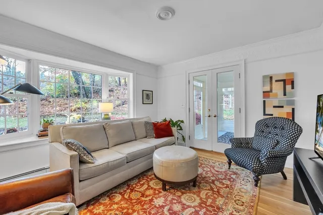 a living room with furniture a flat screen tv and a large window
