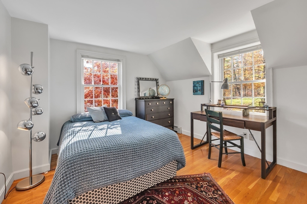 4 Black Hill Road Paxton, MA 01612 - Photo 23 of 42 a bedroom with a bed and a table in it with wooden floor