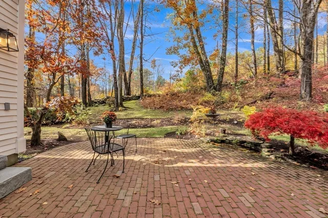a front view of a house with a yard and trees