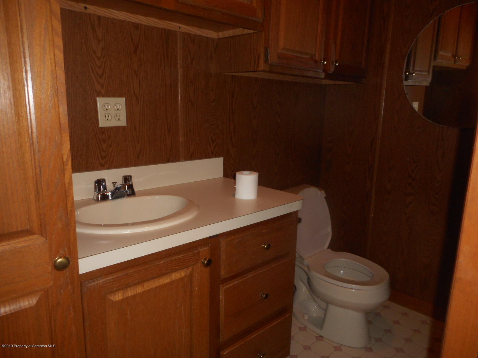 232 Oak Street Old Forge, PA 18518 - Photo 6 of 19 a bathroom with a granite countertop sink a toilet and a mirror