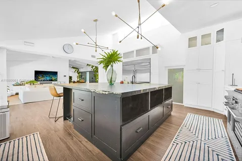 a kitchen with kitchen island white cabinets and stainless steel appliances