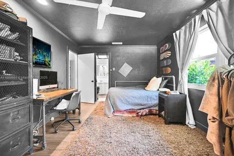 a living room with furniture a flat screen tv and floor to ceiling window