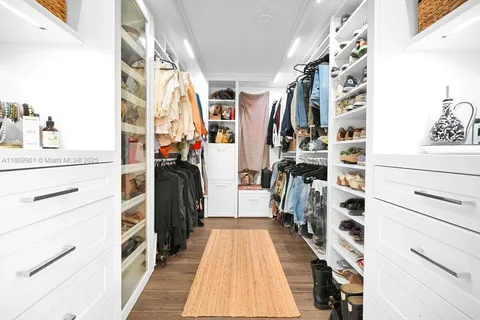 a view of walk in closet with clothes and shoes
