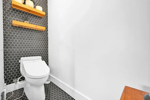 a white toilet sitting next to a small white wall