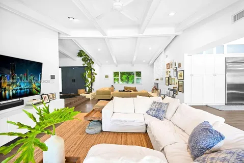 a living room with furniture potted plant and a large window