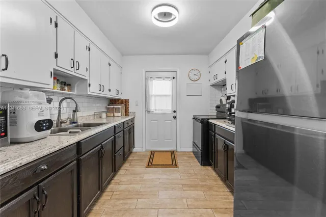 a large kitchen with stainless steel appliances granite countertop a stove and a sink